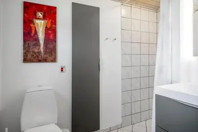 a bathroom with a toilet and a painting on the wall at 534-Thisted-Fiskervej-123 in Thisted