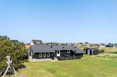 a house with a black roof on a yard at 534-Thisted-Fiskervej-123 in Thisted