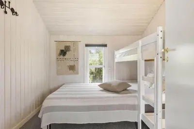 a white bedroom with a bunk bed and a window at 962-Thisted-Bavnbak-27 in Torsted