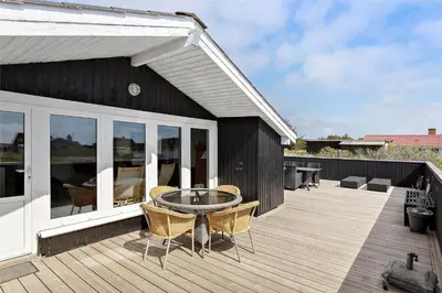 a patio with a table and chairs on a deck at 662-Thisted-Havbovej-18 in Thisted