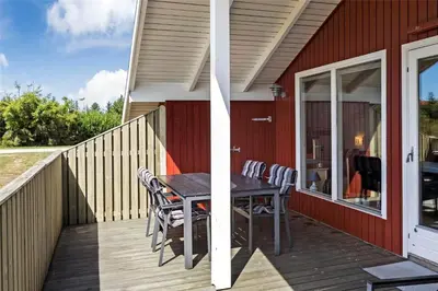 a wooden deck with a table and chairs on a house at 715-Thisted-Tunvej-22 in Thisted