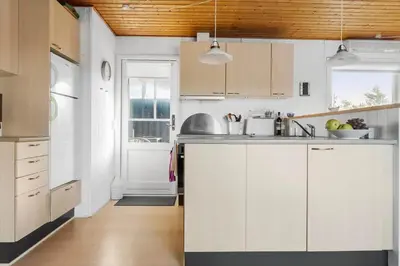 a kitchen with white cabinets and wooden ceilings at 837-Thisted-Flyndervej-17 in Thisted