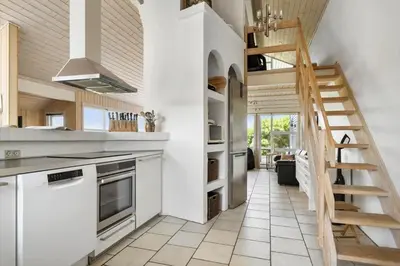 a kitchen with white appliances and a wooden staircase at 950-Thisted-Mombak-1 in Torsted
