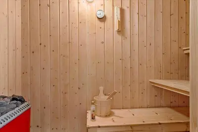 a room with a wooden paneled wall with a bucket in a sauna at 663-Thisted-Nordsovej-166 in Thisted