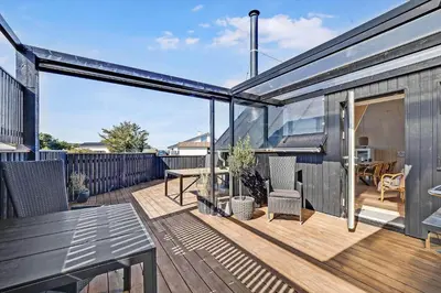 a deck with a table and chairs on a house at 842-Thisted-Orredvej-40 in Thisted
