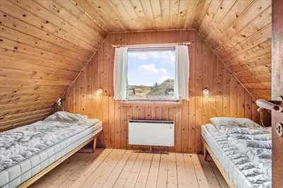two beds in a wooden room with a window at 875-Thisted-Flyndervej-23 in Thisted