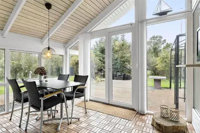 a dining room with a table and chairs and sliding glass doors at 435-Vestervig-Sivsangervej-32 in Vestervig