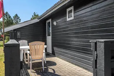 a patio with two chairs and a table in front of a house at 191-Thisted-Bredkaervej-61 in Thisted