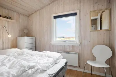 a bedroom with a bed and a chair and a window at 486-Thisted-Fiskervej-57 in Thisted