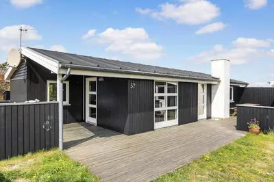 a black and white house with a wooden deck at 486-Thisted-Fiskervej-57 in Thisted