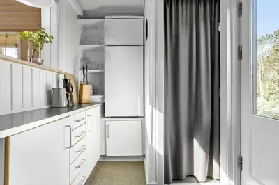 a white kitchen with a refrigerator and a window at 788-Thisted-Blamunkevej-46 in Thisted