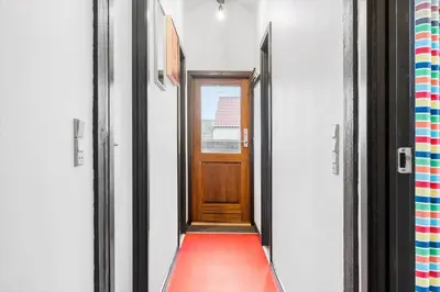 a hallway with a wooden door and a red carpet at 896-Thisted-Fiskervej-81 in Thisted