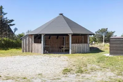 a wooden hut with a table in a field at 896-Thisted-Fiskervej-81 in Thisted