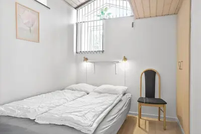 a bedroom with a bed with a chair and a window at 404-Thisted-Klemsvej-16 in Thisted