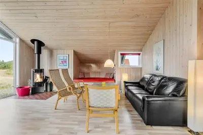 a living room with a black leather couch and a bedroom at 123-Thisted-Orredvej-30 in Thisted