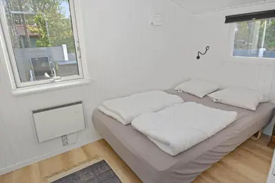 a bed with white sheets in a room with a window at 1321-Thisted-Blamunkevej-58 in Thisted