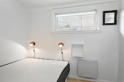 a white bedroom with a bed and a window at 996-Thisted-Bavnbak-25 in Torsted