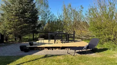 a picnic table and a chair on a wooden deck at 170-Thisted-Sotungevej-2 in Thisted