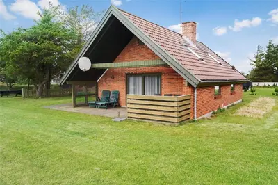 a small brick house with a porch in a field at 400-Thisted-Nordsovej-186 in Thisted