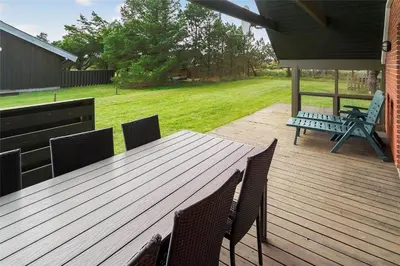 a wooden deck with a picnic table and chairs at 400-Thisted-Nordsovej-186 in Thisted