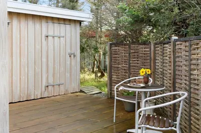 a patio with a table and chairs and a fence at 269-Vestervig-Blishonevej-19 in Vestervig