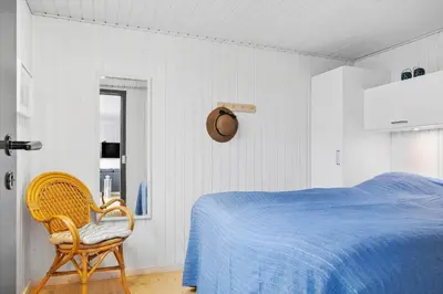 a bedroom with a blue bed and a chair at 269-Vestervig-Blishonevej-19 in Vestervig