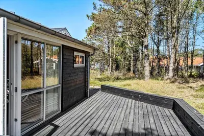 a cabin with a wooden deck and a glass door at 286-Thisted-Blamunkevej-49 in Thisted