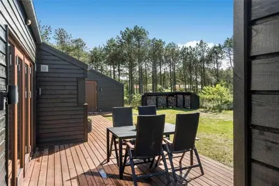 a patio with a table and chairs on a deck at 748-Thisted-Blamunkevej-65 in Thisted