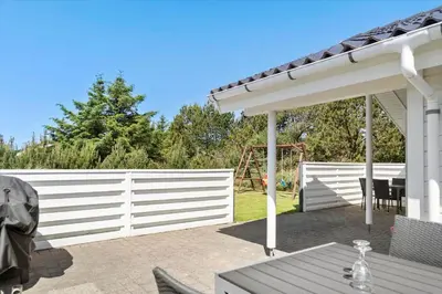 a patio with a white fence and a table at 878-Thisted-Smedevej-15 in Thisted
