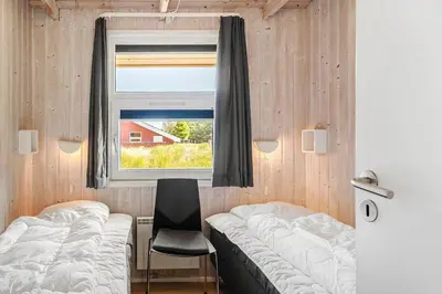 a bedroom with a bed and a window and a chair at 233-Thisted-Tunvej-5 in Thisted