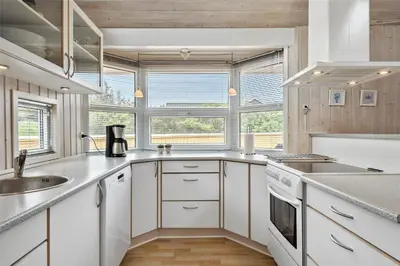 a kitchen with white cabinets and a large window at 233-Thisted-Tunvej-5 in Thisted