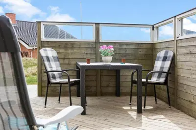 a patio table with two chairs and a vase with flowers at 262-Vestervig-Magevej-15 in Vestervig