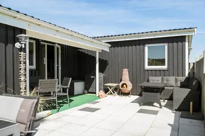 a patio with a couch and a table and chairs at 306-Vestervig-Klitvej-6 in Vestervig