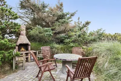 a patio with a table and chairs and a fireplace at 806-Thisted-Nordsovej-39 in Thisted