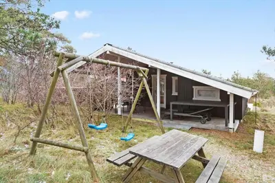a swing set in front of a tiny house at 851-Thisted-Blabaervej-1 in Thisted