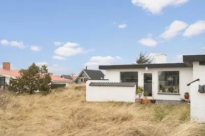 a white house in a field of tall grass at 426-Thisted-Havbovej-26 in Thisted