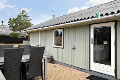 a house with a table and chairs on a patio at 802-Thisted-Pighvarvej-22 in Thisted