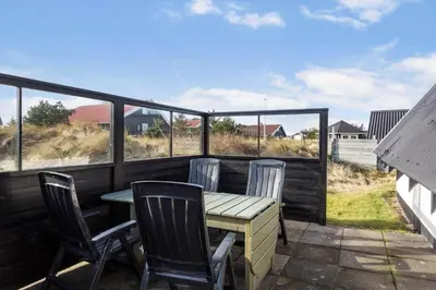 a table and chairs on a deck with a view of the ocean at 169-Thisted-Fiskervej-69 in Thisted
