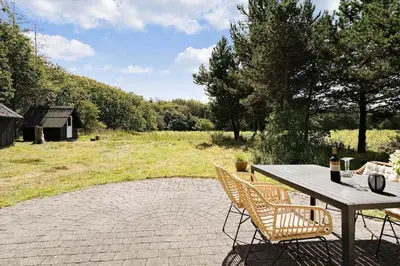 a patio with a table and chairs and a field at 510-Thisted-Egebaksandevej-10 in Thisted