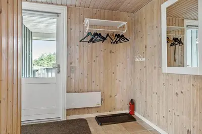 a room with a wooden wall with a door and hangers at 658-Thisted-Laksevej-8 in Thisted