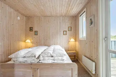 a bedroom with a bed with a wooden wall at 658-Thisted-Laksevej-8 in Thisted