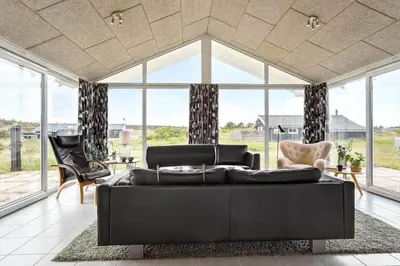 a living room with a black couch and chairs at 994-Thisted-Gravsesvej-20 in Torsted