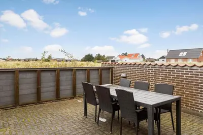 a table and chairs on a patio with a brick wall at 648-Thisted-Kuttervej-8 in Thisted