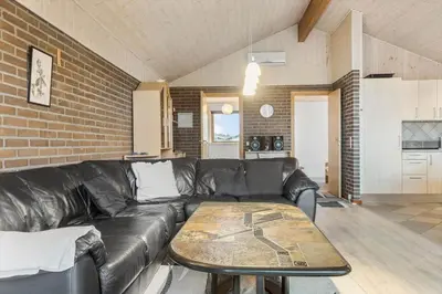 a living room with a black leather couch and a table at 648-Thisted-Kuttervej-8 in Thisted