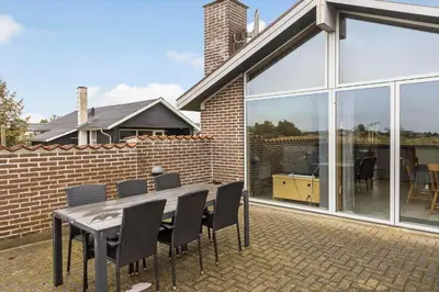 a patio with a table and chairs and a brick wall at 648-Thisted-Kuttervej-8 in Thisted