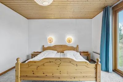 a bedroom with a wooden bed with blue curtains at 648-Thisted-Kuttervej-8 in Thisted