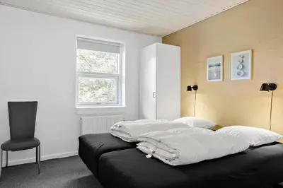 a bed in a room with a chair and a window at 650-Thisted-Orredvej-9-A in Thisted