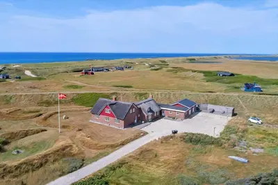 an aerial view of a house in a field with the ocean at 188-Vestervig-Aalumvej-48 in Vestervig