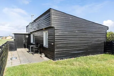 a small black house with a table and chairs at 790-Thisted-Nordsovej-90 in Thisted