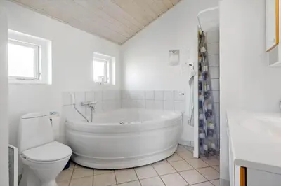a white bathroom with a tub and a toilet at 546-Thisted-Kuttervej-16 in Thisted